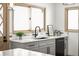 Well-lit kitchen with white cabinets, modern black faucet, and a view from the large windows at 11710 Spruce Canyon Cir, Golden, CO 80403