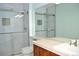 Bathroom featuring tile floors, marbled tile walls, glass enclosed shower, and ample vanity storage at 2819 Canyon Crest Dr, Highlands Ranch, CO 80126