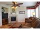 Comfortable living room featuring a ceiling fan, fireplace, and a plush brown sofa at 2819 Canyon Crest Dr, Highlands Ranch, CO 80126
