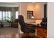 Bright office with wood floors, a large desk, a comfortable chair, and views into the living room at 2819 Canyon Crest Dr, Highlands Ranch, CO 80126