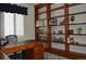 Bright home office featuring custom wood shelving and a large desk at 2819 Canyon Crest Dr, Highlands Ranch, CO 80126