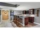 Finished basement wet bar with seating, decorative wall art, and wood-look tile flooring at 16123 Quarry Hill Dr, Parker, CO 80134