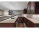 Basement wet bar with granite countertops, wood cabinets, and an under-counter refrigerator at 16123 Quarry Hill Dr, Parker, CO 80134
