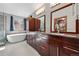 Bathroom with double vanity, a bathtub, and a walk-in closet with custom storage solutions at 16123 Quarry Hill Dr, Parker, CO 80134