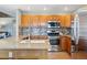 Modern kitchen with wooden cabinets, stainless steel appliances, granite countertops, and island sink at 16123 Quarry Hill Dr, Parker, CO 80134