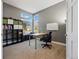 Bright office with large windows, neutral carpet, and black shelving unit at 16123 Quarry Hill Dr, Parker, CO 80134