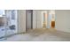 Bedroom with neutral carpet, a closet, access to a bathroom and an exterior patio at 8300 S Upham Way, Littleton, CO 80128