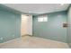 A cozy bedroom boasts soft carpeting, a window with curtains, and a calming green color palette at 8300 S Upham Way, Littleton, CO 80128