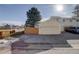 A two-car garage featuring a large door and paved driveway and well kept fencing and landscaping at 8300 S Upham Way, Littleton, CO 80128