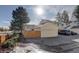 This garage is spacious, with a large driveway and mature landscaping around the property at 8300 S Upham Way, Littleton, CO 80128