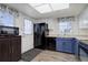 Functional kitchen featuring black appliances, blue cabinets, and a convenient layout at 8300 S Upham Way, Littleton, CO 80128