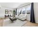 Bright living room with a white couch, large windows with blue curtains, and hardwood floors at 9055 Holland St, Broomfield, CO 80021