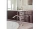 Close up of the dual sink vanity featuring granite countertops and dark wood cabinets at 7899 S Country Club Pkwy, Aurora, CO 80016