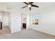 Well-lit bedroom with neutral carpet, a ceiling fan, a bathroom ensuite, and a hallway at 7899 S Country Club Pkwy, Aurora, CO 80016
