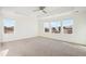 Bright Primary bedroom with neutral carpet, ceiling fan, and three large windows at 7899 S Country Club Pkwy, Aurora, CO 80016