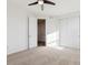 Bright bedroom featuring neutral carpet, ceiling fan, and sliding closet doors at 7899 S Country Club Pkwy, Aurora, CO 80016