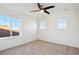 Bright bedroom featuring neutral carpet, ceiling fan, and ample natural light from multiple windows at 7899 S Country Club Pkwy, Aurora, CO 80016