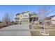 Charming two-story home showcasing a well-maintained lawn, three-car garage, and classic architectural details at 7899 S Country Club Pkwy, Aurora, CO 80016