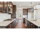 Well-equipped kitchen with dark wood cabinetry, stainless steel appliances, and light granite countertops at 7899 S Country Club Pkwy, Aurora, CO 80016