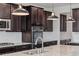 Close-up view of a kitchen with a large island, stainless steel appliances, and dark wood cabinetry at 7899 S Country Club Pkwy, Aurora, CO 80016