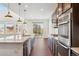 Modern kitchen featuring a large island, stainless steel appliances, and access to the patio at 7899 S Country Club Pkwy, Aurora, CO 80016