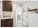 Bright laundry room featuring custom cabinets, sink, and decorative shelving next to entry door at 7899 S Country Club Pkwy, Aurora, CO 80016