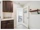 Bright mud/laundry room with sink, dark cabinets, and decorative shelving at 7899 S Country Club Pkwy, Aurora, CO 80016