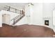 Large living room featuring a fireplace, tall staircase and railing, and hardwood floors at 7899 S Country Club Pkwy, Aurora, CO 80016