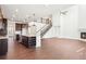Expansive living area featuring dark wood floors, a fireplace, open layout, and a modern kitchen island at 7899 S Country Club Pkwy, Aurora, CO 80016
