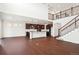 Spacious living area with a center island, hardwood flooring, modern appliances, and a view of the staircase at 7899 S Country Club Pkwy, Aurora, CO 80016