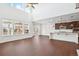Bright living area with large windows, soaring ceilings, dark hardwood floors and an open layout to kitchen at 7899 S Country Club Pkwy, Aurora, CO 80016