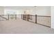Spacious loft featuring decorative wrought iron railing and abundant natural light from nearby windows at 7899 S Country Club Pkwy, Aurora, CO 80016