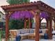 Inviting outdoor space featuring a pergola adorned with purple flowers, offering a cozy seating area at 7899 S Country Club Pkwy, Aurora, CO 80016