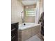 Corner bathtub with tile surround and glass block window providing natural light at 848 S 13Th Ave, Brighton, CO 80601