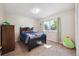 Cozy bedroom with carpet flooring, a black wooden bed frame, and a large window at 848 S 13Th Ave, Brighton, CO 80601