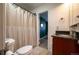 Bathroom features a vanity with dark countertop and cabinet and a shower with curtain at 4673 S Lowell Blvd, Denver, CO 80236