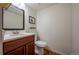 Cozy half bathroom boasts a cherry vanity, modern faucet, and a decorative mirror at 4673 S Lowell Blvd, Denver, CO 80236