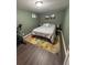 Bedroom with wood laminate flooring and a comfortable bed, along with an exercise bike at 4673 S Lowell Blvd, Denver, CO 80236