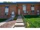 Charming brick townhome with well-maintained lawn and welcoming front entrance with concrete stairs at 4673 S Lowell Blvd, Denver, CO 80236