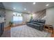 Inviting living room features a comfortable black leather sofa, bright window, and staircase at 4673 S Lowell Blvd, Denver, CO 80236
