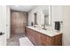 A stylish bathroom featuring a double vanity, wooden cabinets, designer fixtures, and modern tile flooring at 1901 Wazee St # 504, Denver, CO 80202