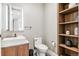 Stylish powder room with a modern vessel sink, sleek vanity, and open wood shelving at 1901 Wazee St # 504, Denver, CO 80202
