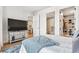 Bright bedroom with a walk-in closet, a sleek TV, and a view into the kitchen and bathroom at 1901 Wazee St # 504, Denver, CO 80202