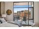 Bright bedroom includes a balcony, city view, and modern decor at 1901 Wazee St # 504, Denver, CO 80202