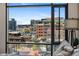 Bright condo featuring an expansive city view through a large window with modern furnishings and sunny blue skies at 1901 Wazee St # 504, Denver, CO 80202