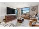 Cozy living room featuring large windows, comfortable leather seating, and a rustic wood media center at 1901 Wazee St # 504, Denver, CO 80202