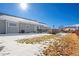 Well-maintained backyard with a deck, lush green grass, and partially snow-covered landscaping for outdoor enjoyment at 51 W 6Th Pl, Byers, CO 80103