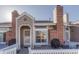 Inviting home exterior featuring brick chimney, neutral siding, and white-picket fenced patio at 9057 Bear Mountain Dr, Highlands Ranch, CO 80126