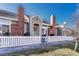 Inviting home exterior featuring brick chimney, neutral siding, and white-picket fenced patio at 9057 Bear Mountain Dr, Highlands Ranch, CO 80126