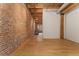 Exposed brick wall and wood beam hallway with hardwood floors at 2960 Inca St # 112, Denver, CO 80202